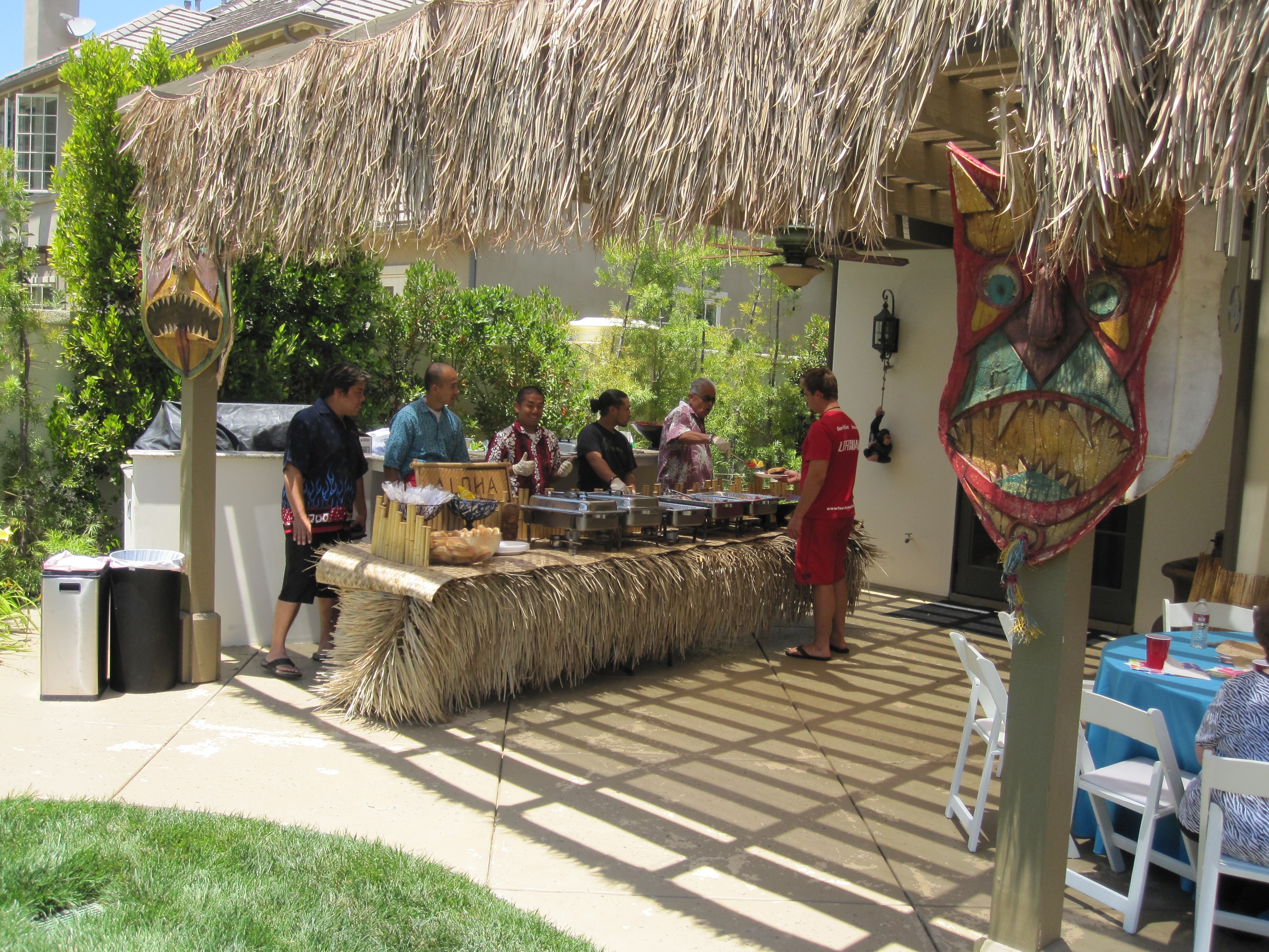 Backyard pool party with tiki umbrellas and luau setup