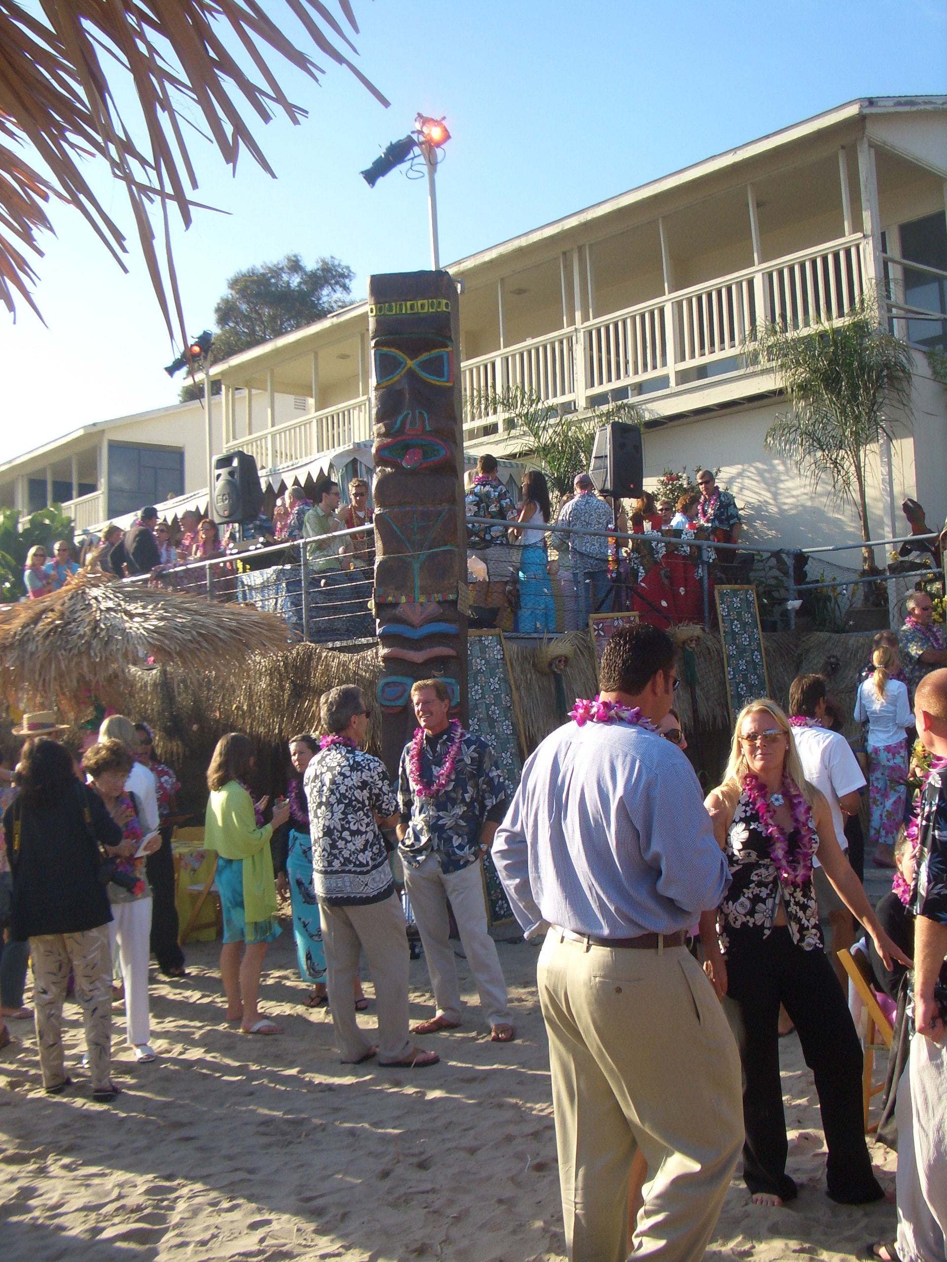 Large-scale convention luau event with crowd and tiki totems
