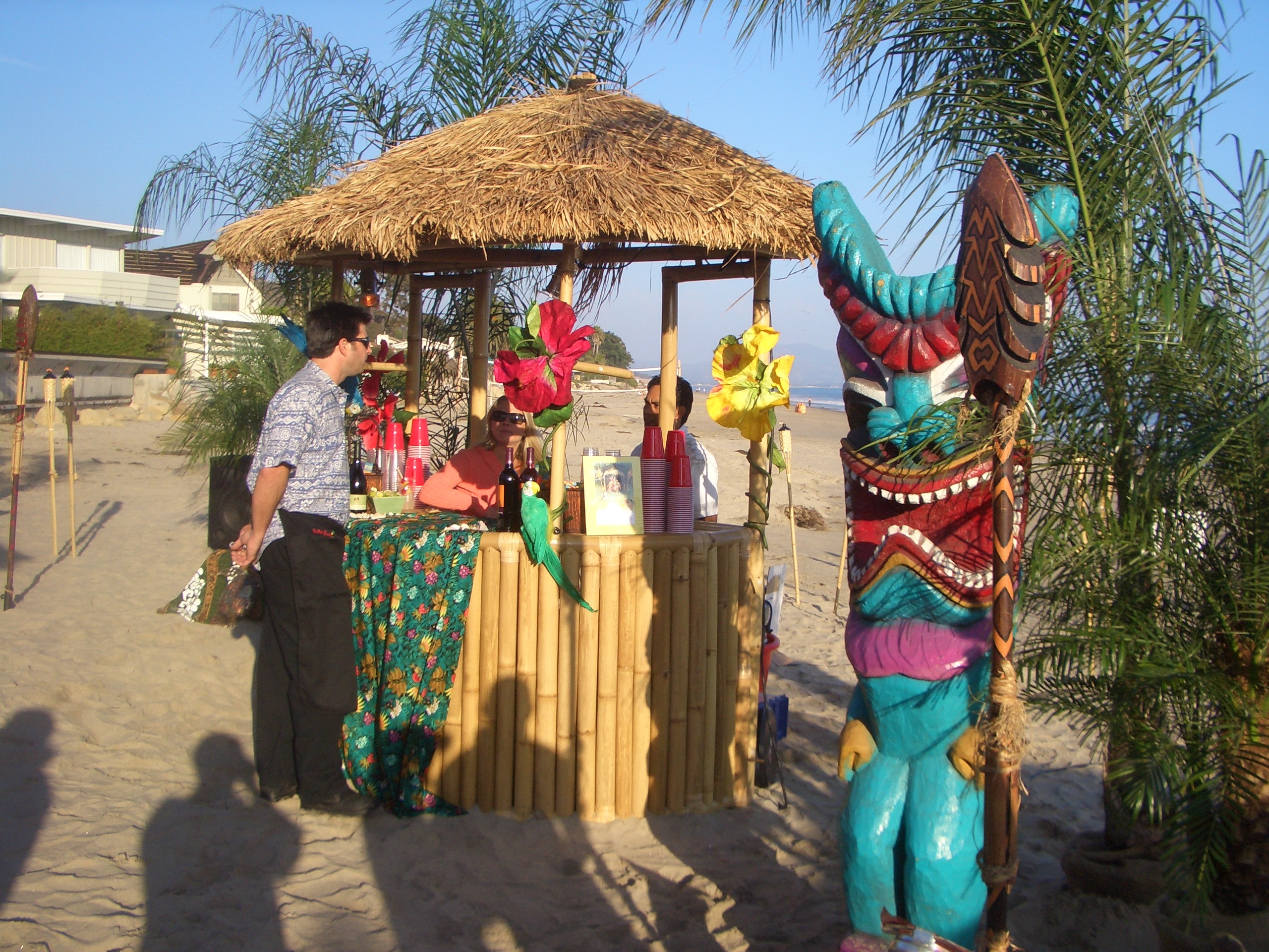 Aloha Welcome entrance arch with tiki statues and tropical flowers